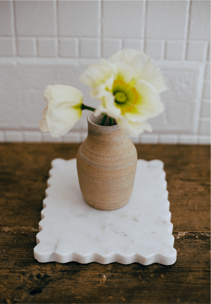 A petite scalloped slab on a table with flowers