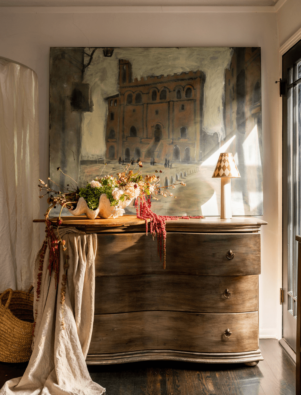 Reclaimed wood dresser with fruit basket on top and painting behind