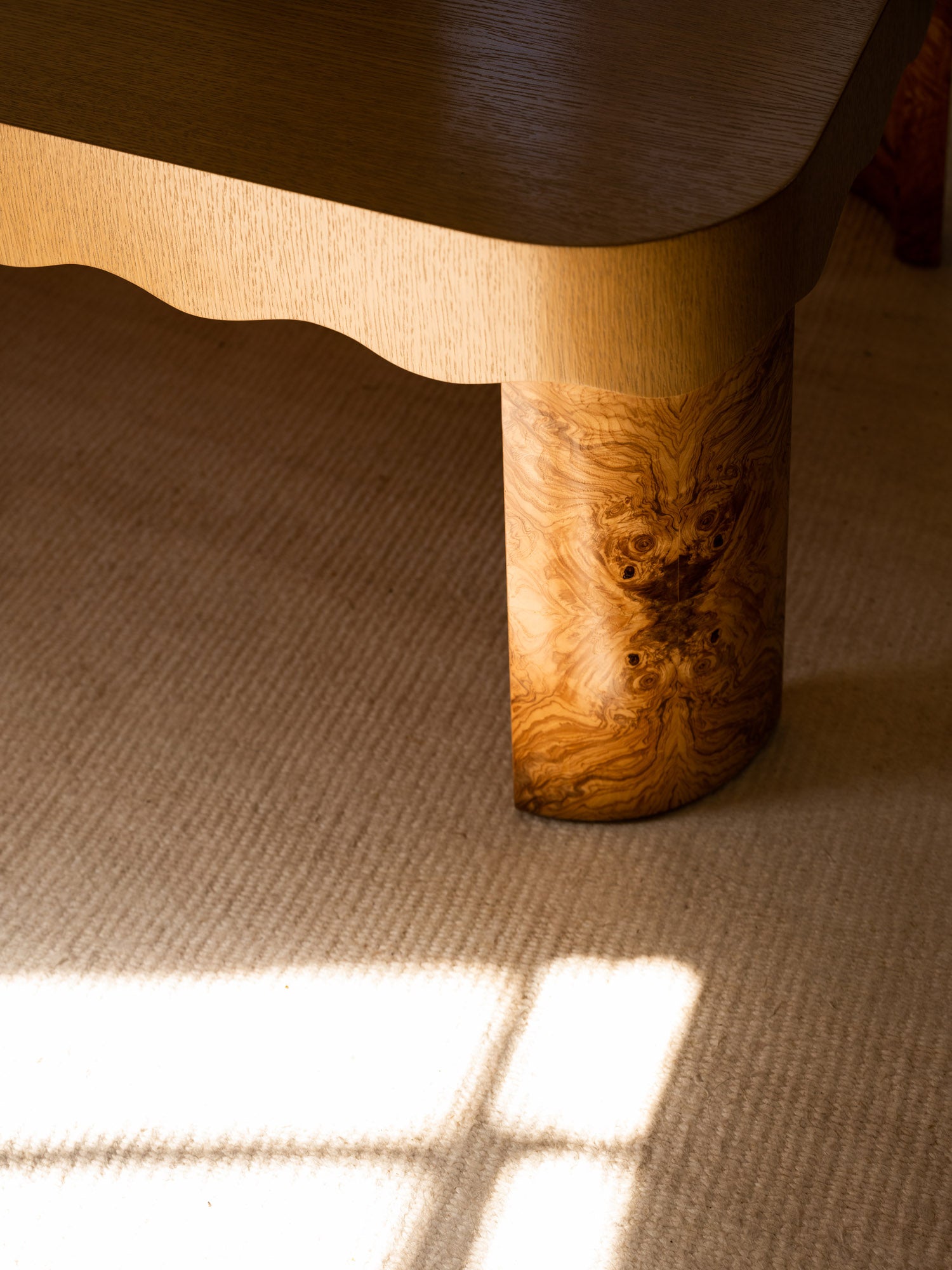 Close up of burl wood legs on scalloped coffee table